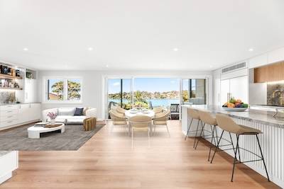Experience luxury living with this open-plan kitchen and dining area featuring stunning waterfront views. Transform your home today with Dura Group.