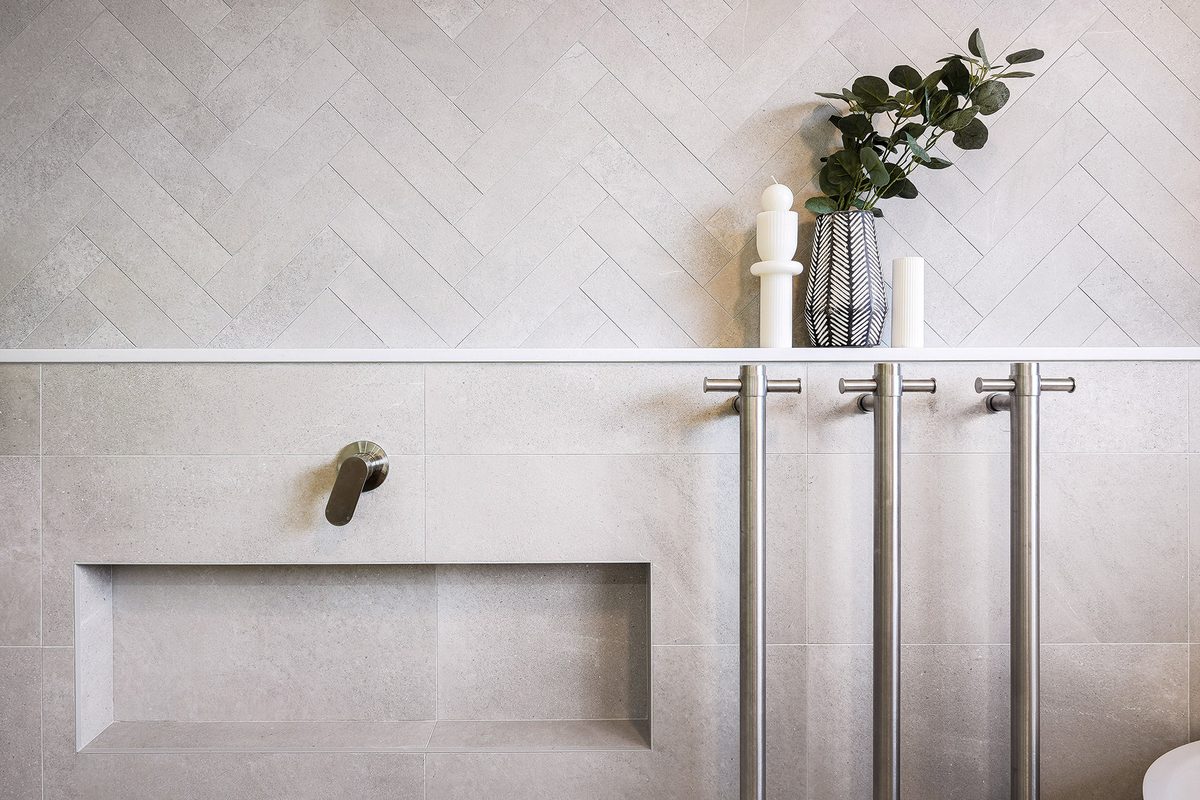 Bathroom detail with herringbone tiling and stone niche shelf