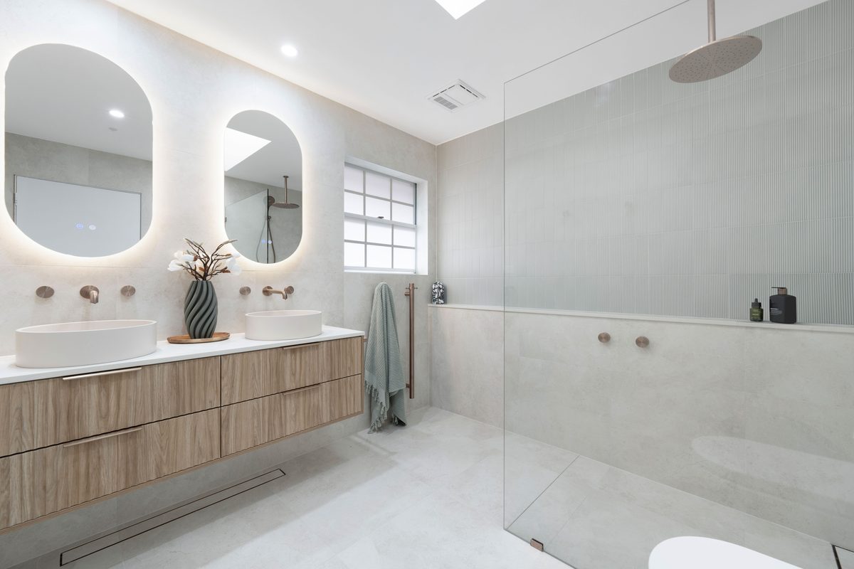 Bathroom renovation with twin backlit arched mirrors