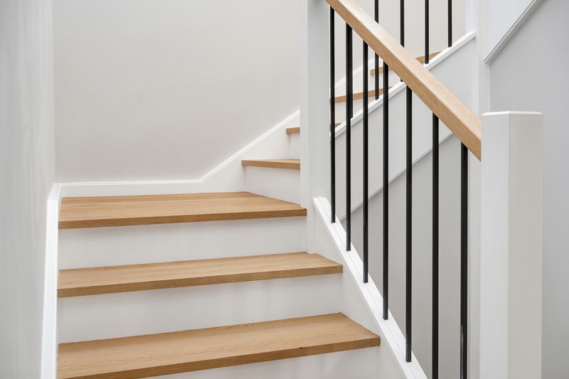 New internal staircase with timber treads and black balustrade, connected after lock-up stage