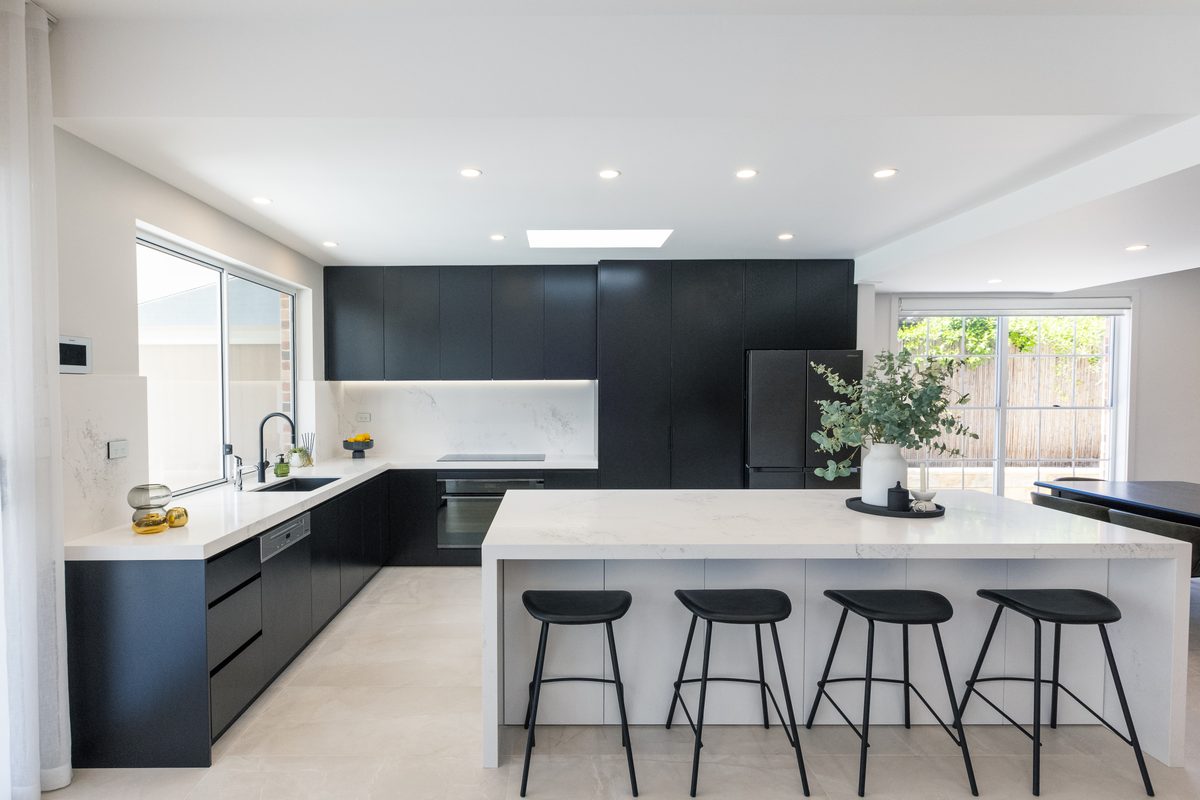 Kitchen renovation with dark cabinetry and white breakfast bar