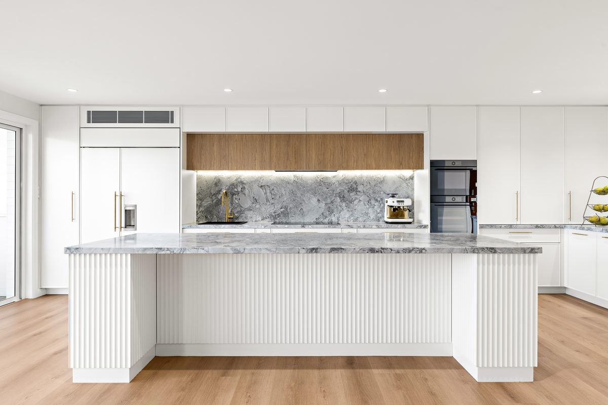 Open-plan kitchen renovation with fluted island and marble splas