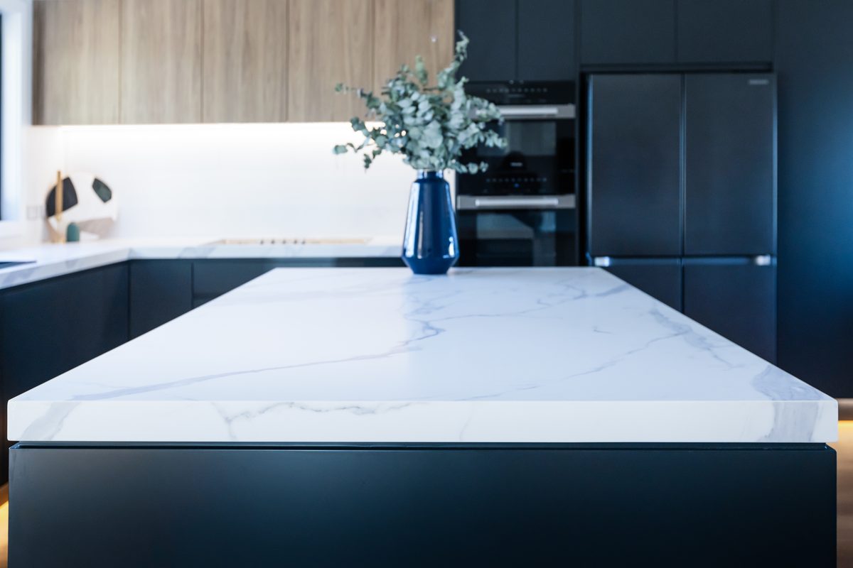 Kitchen detail with marble waterfall island and navy joinery