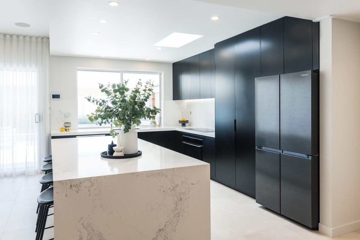 Kitchen renovation with matte black cabinetry and stone island